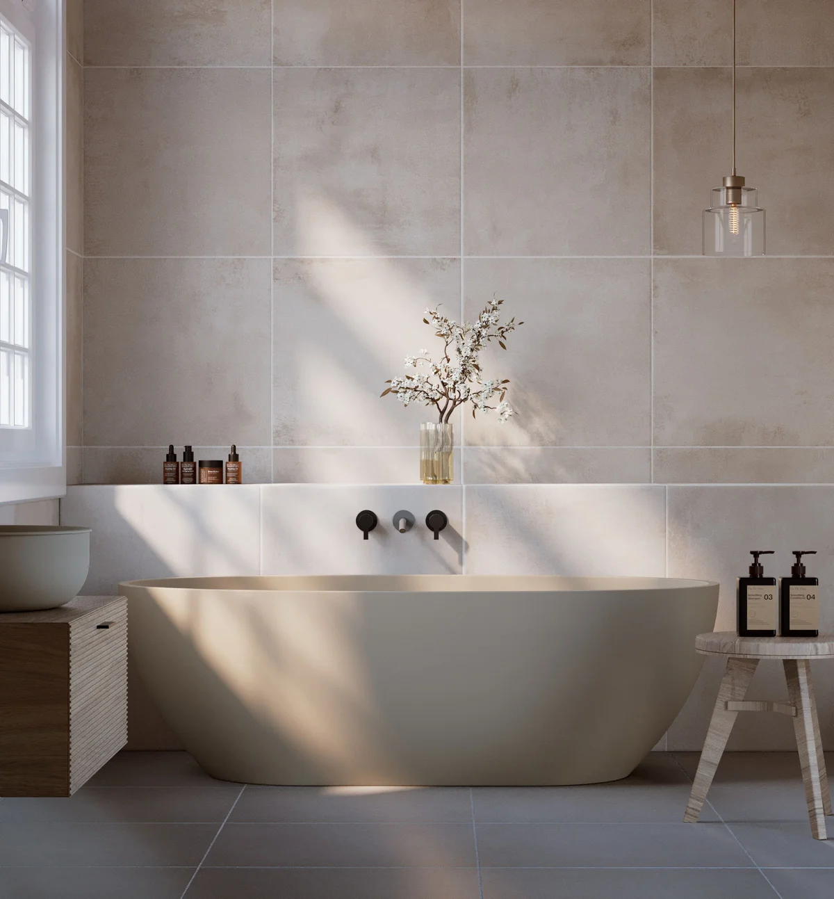 Warm neutral tiles behind a freestanding bath